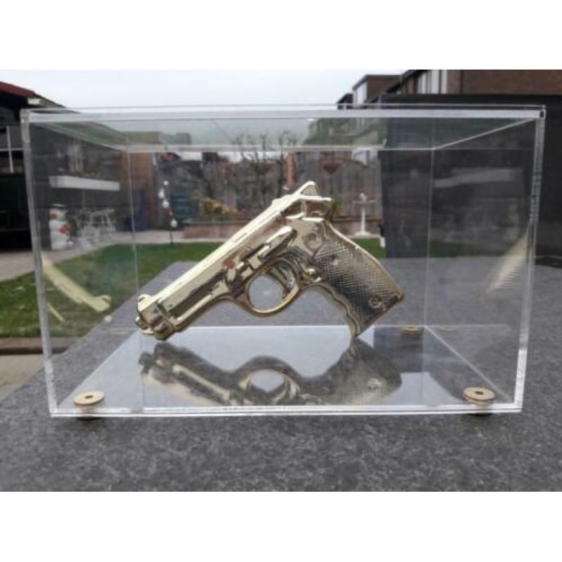 Gouden namaak design pistool / revolver in glazen vitrine.